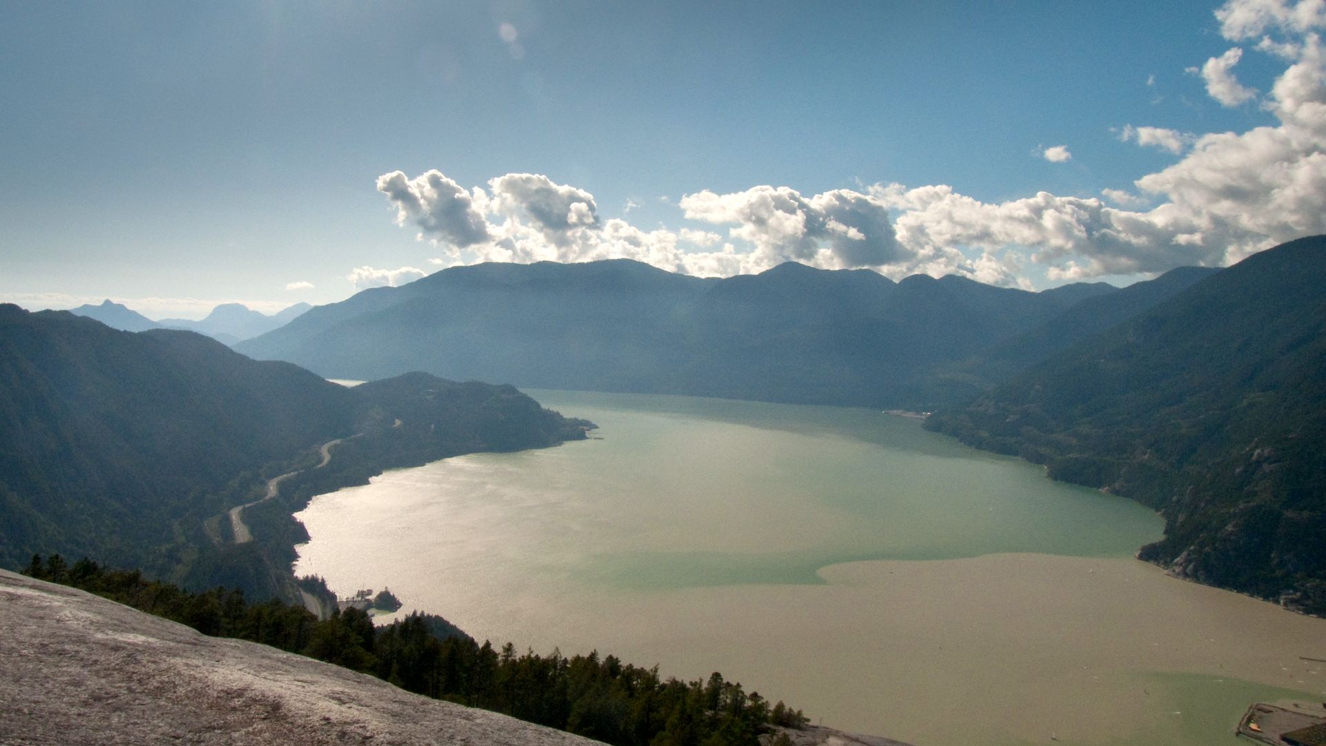 Howe Sound from the top of the Stawamus Chief, the highway tracing the shore below mountains and cloud